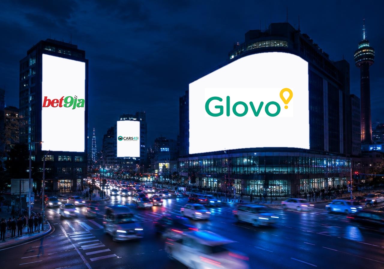 Digital out-of-home screens at night showing Bet9ja, Cars45 and Glovo